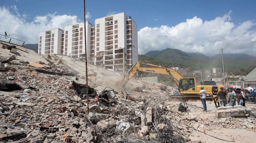 epa13073174 Volunteers conduct search operations in a building damaged by an earthquake in La Guaira, Venezuela, 29 June 2026. National and international rescue teams continue their efforts among the ruins of buildings in the coastal state of La Guaira, north of Caracas, the epicentre of devastation caused by 7.2- and 7.5-magnitude earthquakes, where logistics centres for international teams have been set up.  EPA/RONALD PENA R