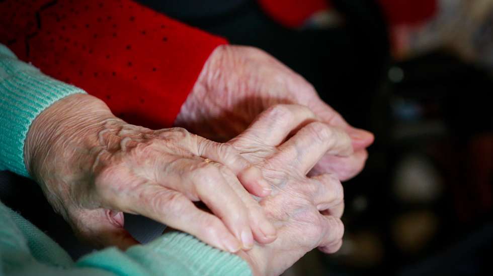 epa08786229 Two friends resident hold each other hands while they watch TV show at the 'Notre Dame De Bonne Esperance' nursing home in Chatelet, Belgium, 30 October 2020. Due to COVID-19, residents of the nursing home are not allowed to leave among the measures taken to protect residents from the spread of coronavirus.  EPA/STEPHANIE LECOCQ