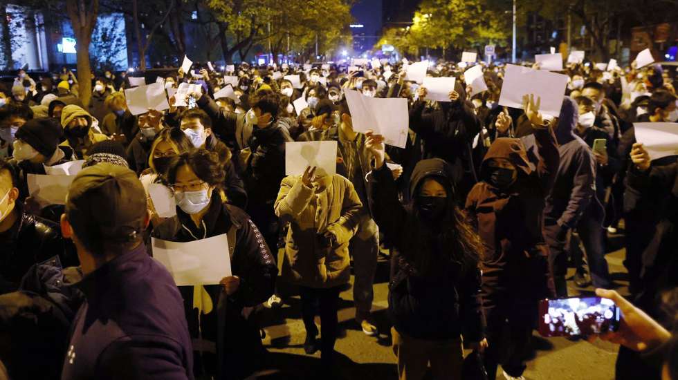 epaselect epa10332665 Protesters hold blank white pieces of paper during a protest triggered by a fire in Urumqi that killed 10 people in Beijing, China, 27 November 2022. Protests against’s China strict Covid restrictions have erupted in various cities including Beijing and Shanghai, triggered by a tower fire that killed 10 people Xinjiang’s capital, Urumqi.  EPA/MARK R. CRISTINO