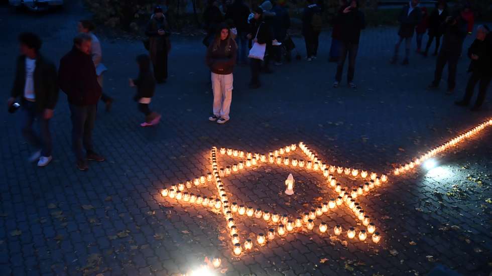 epa10953158 People look at candles forming a star during an event called 'Lighting candles in memory of those murdered by Hamas,' organized by members of the Jewish Religious Community of Warsaw, at the Jewish cemetery in Warsaw, Poland, 01 November 2023. Thousands of Israelis and Palestinians have died since the militant group Hamas launched an unprecedented attack on Israel from the Gaza Strip on 07 October, and the Israeli strikes on the Palestinian enclave which followed it.  EPA/Andrzej Lange POLAND OUT