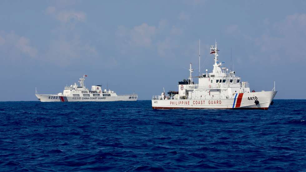 epaselect epa11343753 A Chinese Coast Guard (CCG) patrol ship (L) and a Philippine Coast Guard patrol vessel (R) sail next to one another other on the waters of the disputed South China Sea, 16 May 2024. A civilian-led mission joined by at least a hundred fishermen embarked on Scarborough Shoal in the disputed South China Sea to assert the Philippines' territorial claim. Scarborough Shoal ('Bajo de Masinloc' called by Filipino fishermen), a fishing haven shoal within the Philippine maritime territory that China occupied a decade ago, was recently reported to be driving away Filipino fishermen by Chinese coastguard ships.  EPA/FRANCIS R. MALASIG
