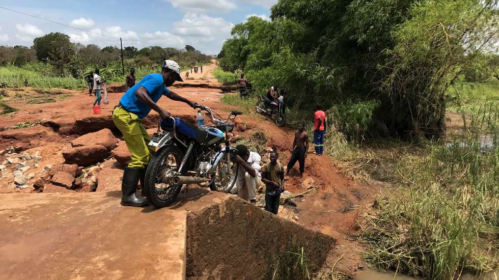 epa09822037 People try to cross Anphawane river after Cyclone Gombe destroyed the Monapo-Mogincual road bridge, in Nampula province, Mozambique, 13 March 2022. Storm Gombe reached the Mozambican coast in the early hours of 11 March morning in the category of an intense cyclone with torrential rain and wind of 165 kilometers per hour, with gusts exceeding 200 km/hour.  EPA/ANDRE CATUEIRA