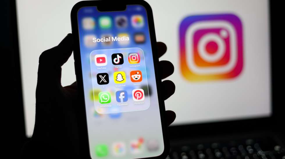 epa12674741 Social media applications displayed on a mobile phone alongside the Instagram logo displayed on a laptop screen in Liverpool, Britain, 23 January 2026. A proposal to ban under-16s from accessing social media in the UK will be considered in the House of Commons after peers in the House of Lords voted 261 to 150 in favour of an amendment to the Children’s Wellbeing and Schools Bill. If adopted, the amendment would require social media companies to implement strict and effective age checks in order to prevent underage users from signing up.  EPA/ADAM VAUGHAN