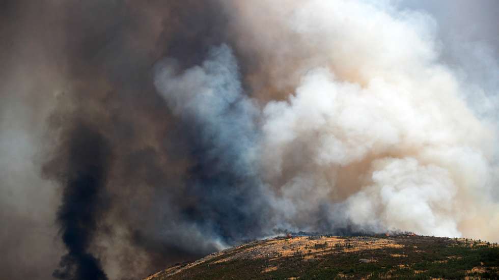 Uma coluna de fumo negro no ar durante o incêndio na encosta da aldeia de Moura da Serra, Arganil, 14 de agosto de 2025. De acordo com os dados disponíveis no ‘site’ da Autoridade Nacional de Emergência e Proteção Civil (ANEPC), quase 900 operacionais combatiam o fogo que deflagrou na quarta-feira na freguesia de Piódão, no concelho de Arganil, distrito de Coimbra, e se estendeu depois aos municípios de Oliveira do Hospital e Pampilhosa da Serra (Coimbra), e de Seia, já no distrito da Guarda. PAULO CUNHA/LUSA