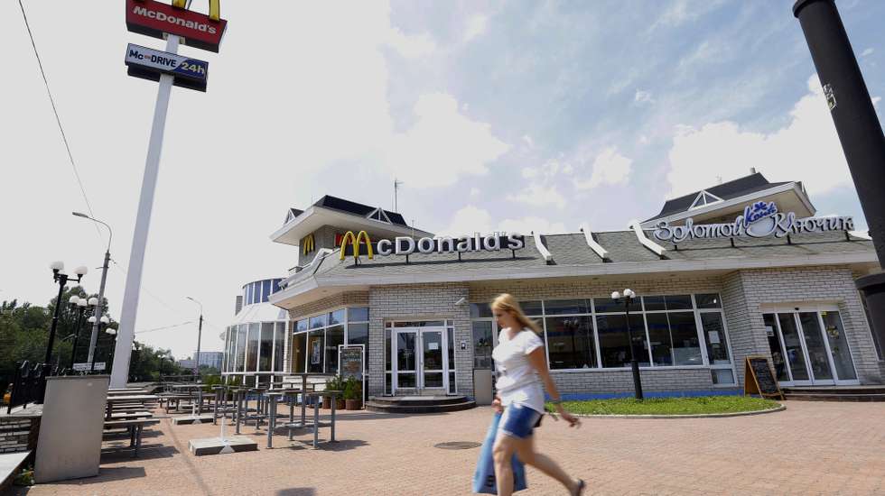 epa04327485 An Ukrainian woman carrying her shopping bag while passing a closed and deserted McDonalds restaurant in the city of  Donetsk, Ukraine, 23 July 2014. The restaurant was closed, and a part of the space is now used for a small grocery store. Donetsk, which is controlled by separatist forces, has become the capital of 'Donetsk People's Republic' (DNR). A 'People's Council' now rules there and the surrounding region, with a population of 4.5 million.  EPA/ROBERT GHEMENT
