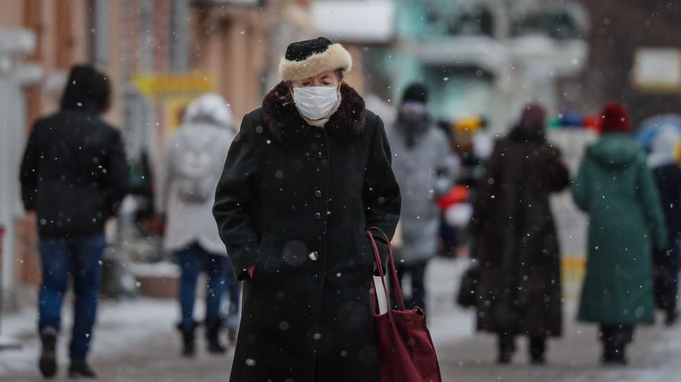 epa09004173 Russian woman wearing a protective face mask on a street in Moscow, Russia, 11 February 2021, during the pandemic of SARS-CoV-2 coronavirus. In some regions of Russia, the authorities have canceled the mandatory masks regime. The new rules will take effect from 12 February.  EPA/YURI KOCHETKOV