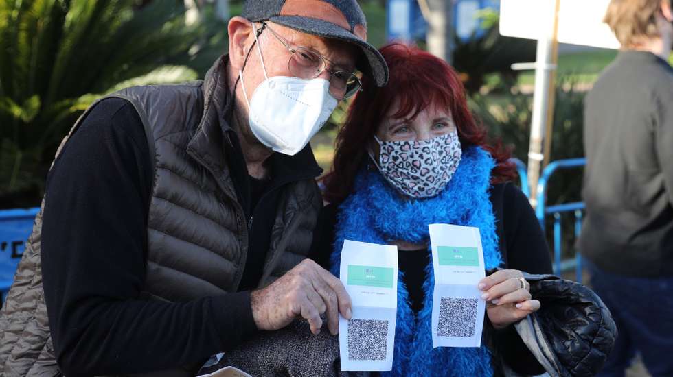 epa09033882 People present their coronavirus vaccination certificate or 'green badge' at the entrance of a music concert in Tel Aviv, 24 February 2021. Israel reopened cultural hubs for people with a vaccination certificate or 'green badge', after months of closure due to the coronavirus pandemic. Israel started lifting some of its coronavirus restrictions and allowed the use of 'Green Badge' app for vaccination certificate for people who have received two doses of the coronavirus vaccine.  EPA/ABIR SULTAN