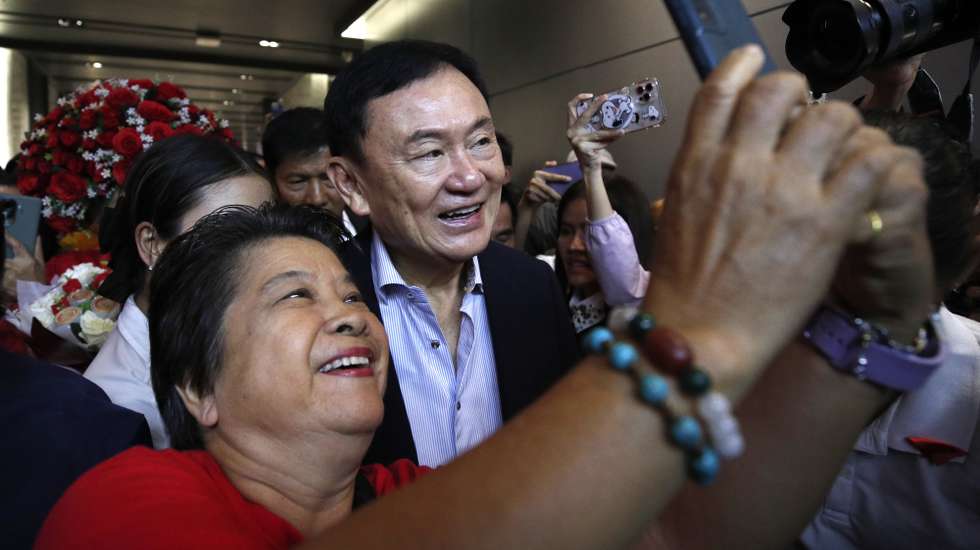 epa11244139 Thailand's former Prime Minister Thaksin Shinawatra (C) is photographed by a supporter during his public appearance to visit Pheu Thai Party's members at Pheu Thai Party headquarters in Bangkok, Thailand, 26 March 2024. Shinawatra was released on parole from the Police General Hospital where he had been detained for six-months of his one-year jail sentence and did not spend a single night behind bars for corruption and power abuse due to multiple illnesses. Shinawatra returned to Thailand in August 2023 from living in self-imposed exile after he was overthrown by a military coup on 19 September 2006.  EPA/RUNGROJ YONGRIT