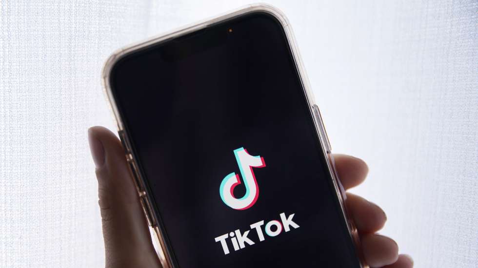 epa10635388 In this photo illustration a person holds up a cell phone with the TikTok logo displayed in Los Angeles, California, USA, 17 May 2023. Govenor Greg Gianforte of Montana signed a measure that bans the TikTok app in the state.  EPA/CAROLINE BREHMAN