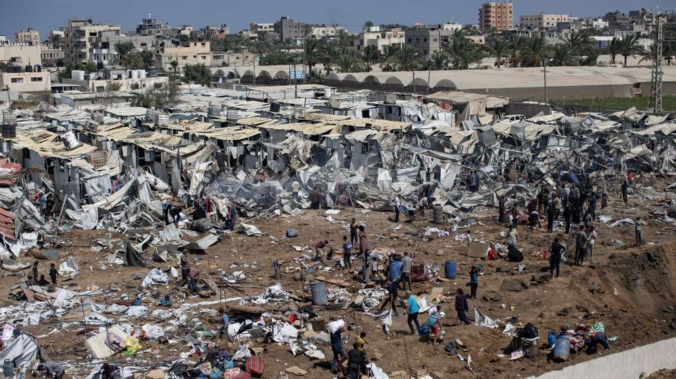 epa12314038 Displaced Palestinians inspect tents destroyed after an Israeli strike on the Al-Manasrah camp, which housed more than 200 families in Deir al-Balah, central Gaza Strip, 21 August, 2025.  EPA/HAITHAM IMAD