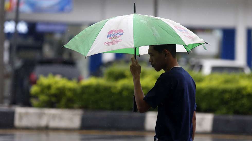 epa12549214 A man use an umbrella under heavy rain in Banda Aceh, Indonesia, 26 November 2025. The Meteorology, Climatology, and Geophysics Agency (BMKG) issued an early warning for extreme weather across the island of Sumatra, from Aceh to West Sumatra. The severe weather, including heavy rainfall with high intensity, has caused hydrological disasters such as flash floods and landslides in several areas of Aceh and North Sumatra. The latest data released by the National Disaster Management Agency (BNPB) indicates that 17 people have died and 58 have been injured due to flooding and landslides in North Sumatra province.  EPA/HOTLI SIMANJUNTAK