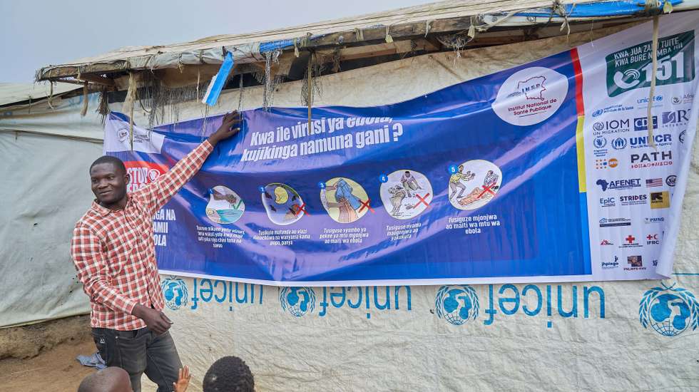 epa13190900 A staff member explains Ebola virus prevention measures to refugees in the CECA camp in Mambasa, Ituri province, Democratic Republic of Congo, 25 August 2026. The local branch of the New Civil Society of Congo (Nouvelle Societe Civile du Congo SOCICO) reported that delays in laboratory results are fueling community resistance to Ebola response measures, compounded by ongoing insecurity in the area.  EPA/DIEUDONNE DIROLE