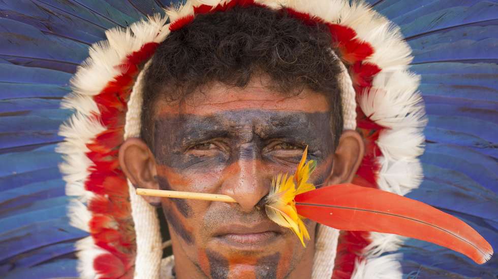 epaselect epa05927817 A Brazilian indigenous person stand in a protest next to Explanada dos Ministerios in Brasilia, Brazil, on 25 April 2017. Close to 2,000 indigenous people of several tribes of the country gathered in Brasilia to demand for the demarcation of their lands, which they claim as their own, in a protest that included brief confrontations with the Police in front of the Congress of Brazil.  EPA/Joédson Alves