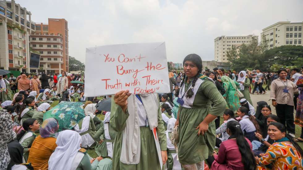 epa12253015 Bangladeshi students shout slogans and hold placards near the crash site after an air force training aircraft crashed into Milestone College campus in Dhaka, Bangladesh, 22 July 2025. According to the Inter-Services Public Relations (ISPR), the death toll from the 21 July aircraft crash at Milestone School and College in Dhaka’s Uttara has risen to 31. Additionally, 165 others were injured in the incident.  EPA/MONIRUL ALAM