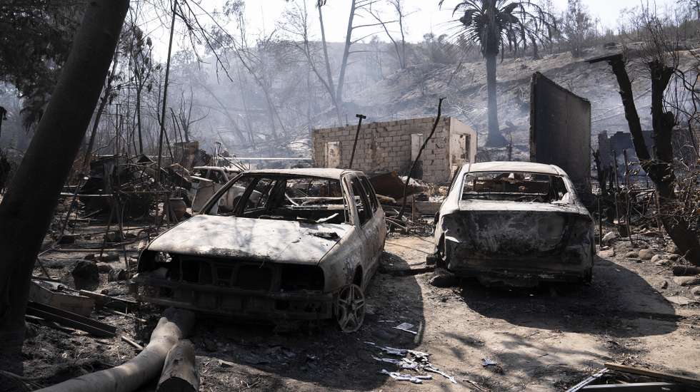 epaselect epa11129809 Burned cars stand outside the devasted home of Patricia Araya, known as 'La Pati,' a staff at the Botanical Garden of Vina del Mar who died in a fire along with her mother and her two grandchildren, aged 9 and one, in Vina del Mar, Chile, 05 February 2024. A fire devasted the Botanical Garden of the coastal city of Vina del Mar over the weekend of 03-04 February 2024. At least 122 people were killed in the wildfires that swept through swaths of Chile, authorities said on 05 February, including a staff of the botanical garden and three of her relatives. Chilean President Boric declared a state of emergency in areas affected by the fires.  EPA/Adriana Thomasa