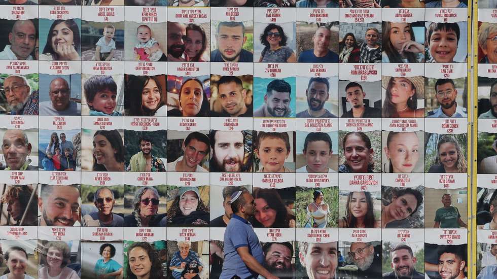 epa11760216 People walk past a billboard showing pictures of Israeli hostages held by Hamas in Gaza, in Tel Aviv, Israel, 06 December 2024. According to the Israeli army (IDF), around 100 Israeli hostages remain in captivity in the Gaza Strip, including bodies of 33 confirmed dead.  EPA/ABIR SULTAN