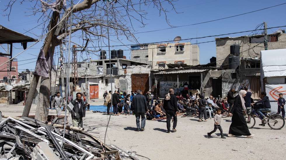 epa11222112 Palestinians arrive to perform the first Friday prayer during the holy month of Ramadan next to the ruins of a mosque destroyed earlier by an Israeli raid in Rafah, southern Gaza Strip, 15 March 2024. Ramadan is the ninth month in the Islamic calendar and it is believed that the revelation of the first verse in the Koran was during its last 10 nights. It is celebrated yearly by praying during the night time and abstaining from eating, drinking, and sexual acts during the period between sunrise and sunset. It is also a time for socializing, mainly in the evening after breaking the fast and a shift of all activities to late in the day in most countries.  EPA/HAITHAM IMAD