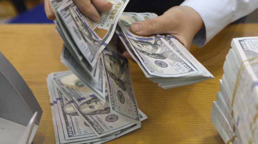 epa10193215 A staff member counts US dollars banknotes at a bank in Hanoi, Vietnam, 19 September 2022. The USD/VND exchange rate has increased by more than 3.6 percent since the beginning of 2022, the highest in history, according to media reports.  EPA/LUONG THAI LINH