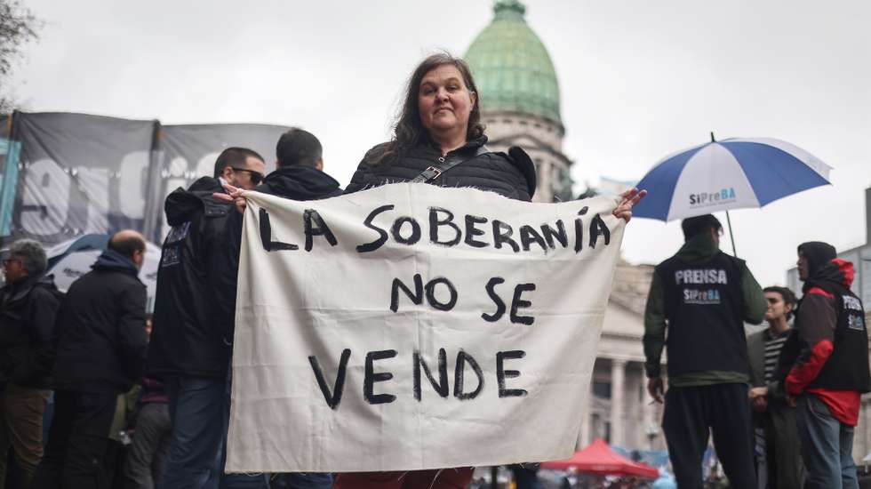 epa13154508 A person holds a sign at a demonstration against a bill promoted by the government of ultraliberal Javier Milei that introduces changes to eviction, expropriation, and the use of burned land processes, in Buenos Aires, Argentina, 06 August 2026.  EPA/Juan Ignacio Roncoroni