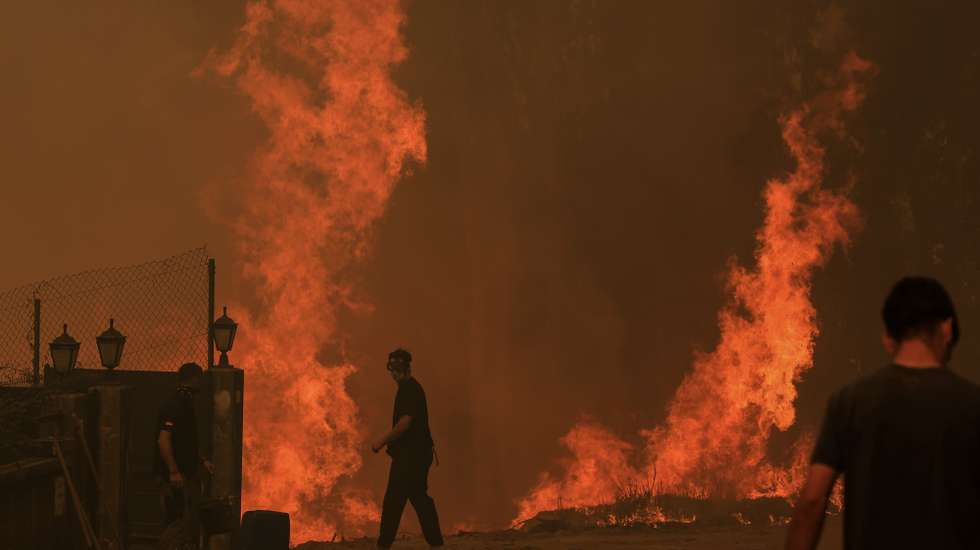 Residentes protegem as suas habitações do incêndio em Covelo, Gondomar, 17 de setembro de 2024. Desde domingo, as chamas chegaram aos distritos do Porto, em Gondomar, de Braga, em Cabeceiras de Basto, de Viseu, em Penalva do Castelo e Nelas (com seis feridos), e de Castelo Branco, em Louriçal do Campo. Mas foi o distrito de Aveiro, com 10 mil hectares já ardidos, o centro dos maiores focos de incêndio, em Oliveira de Azeméis, Sever do Vouga, Albergaria-a-Velha e Águeda. JOSÉ COELHO/LUSA