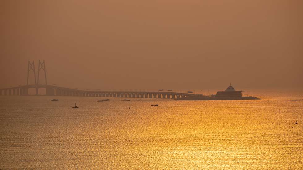 epa08372312 The Zhuhai Link Road of the Hong Kong-Zhuhai-Macau Bridge spans over the South China Sea as seen from Hong Kong, China, 19 April 2020 (issued 20 April 2020). According to figures released by the Transport and Housing Bureau to the Legislative Council, the number of passengers travelling via the local port of the bridge in February 2020 stood at 205,300, down from about 2.08 million a year ago, a drop of 90 percent.  EPA/JEROME FAVRE