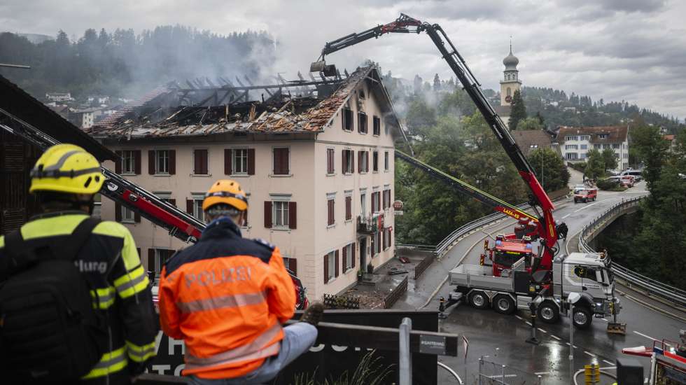 epa13182439 Firefighters try to put out a fire at a building with a restaurant and apartments in Thusis in eastern Switzerland, 21 August 2026. Five people are reported missing following a major fire, while 14 people managed to escape the building.  EPA/GIAN EHRENZELLER