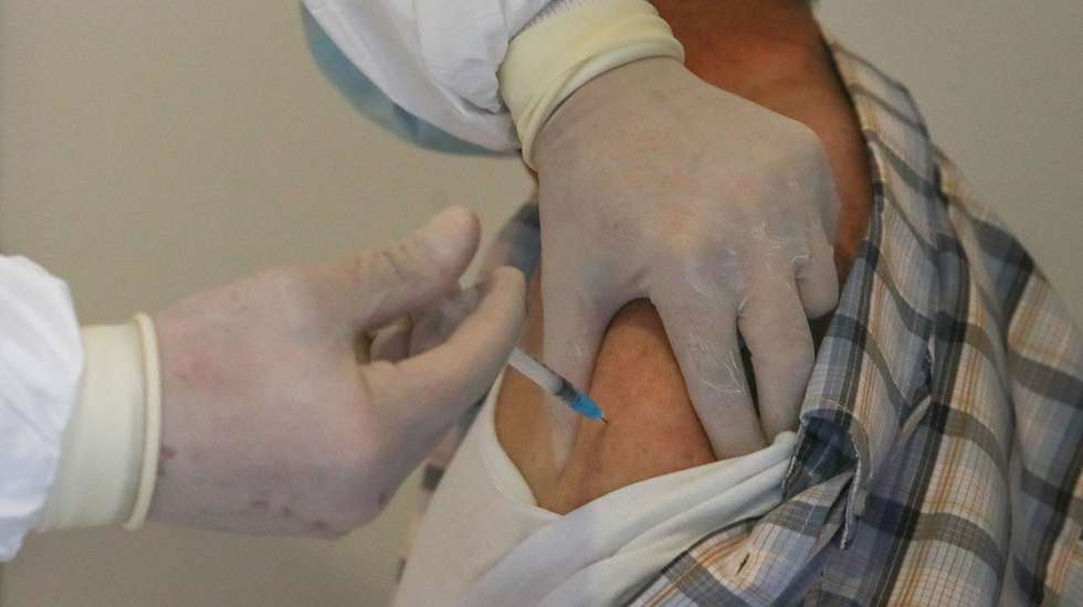 Um idoso é vacinado contra a covid-19 por um profissional de saúde no Centro de Vacinação de Arganil, durante o processo de vacinação na Antiga Cerâmica Arganilense, em Arganil, 19 de março de 2021. (ACOMPANHA TEXTO). PAULO NOVAIS/LUSA