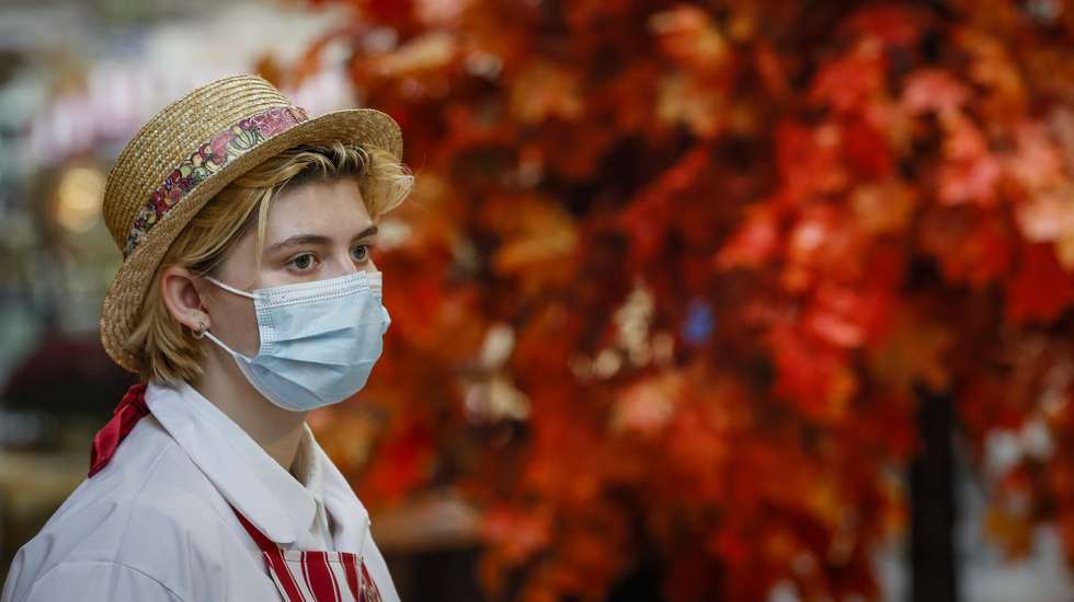 epa09505703 A vendor wearing a protective face mask at the State Department store GUM in Moscow, Russia 04 October 2021. Russia is facing a new wave of Covid-19 infections, with additional 883 coronavirus-related deaths reported on 04  October bringing the official coronavirus death toll to 210 801.  EPA/YURI KOCHETKOV