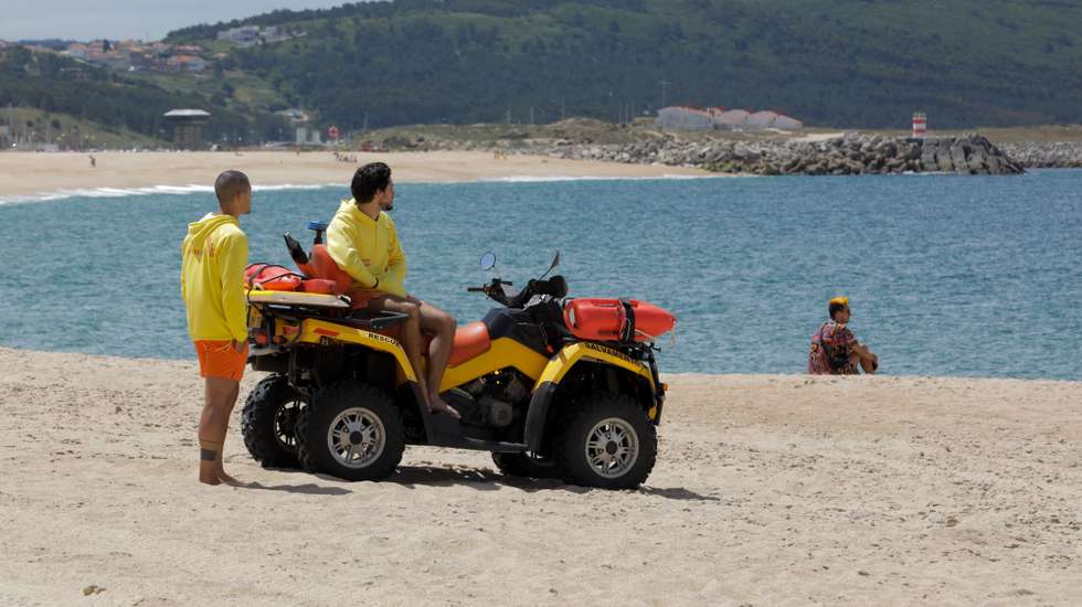 Nadadores Salvadores observam turistas onde sem sol e com poucos banhistas, a época balnear arrancou hoje com mais gente na marginal e nas esplanadas do que na praia da Nazaré, onde não falta espaço para cumprir distâncias de segurança, Nazaré, Leiria, 6 de junho de 2020. Com algumas nuvens a toldar o sol e a tornar a praia menos convidativa, era na marginal da Nazaré que manhã cedo se concentrava o movimento, com passeantes e atletas a cruzarem-se no passeio largo. PAULO CUNHA /LUSA