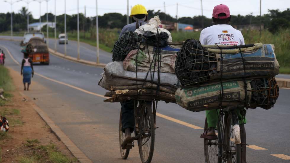 Carvoeiros transportam carvão vegetal nas suas bicicletas junto à Estrada Nacional 6 (EN6), no Chimoio, Moçambique, 15 de junho de 2022. Há cada vez menos florestas e estão cada vez mais longe, um sinal de que a luta contra as alterações climáticas é ainda mais difícil numa África onde a sobrevivência diária é mais importante que salvar o futuro da terra. (ACOMPANHA TEXTO DA LUSA DO DIA 16 DE JUNHO DE 2022). ANDRÉ CATUEIRA/LUSA