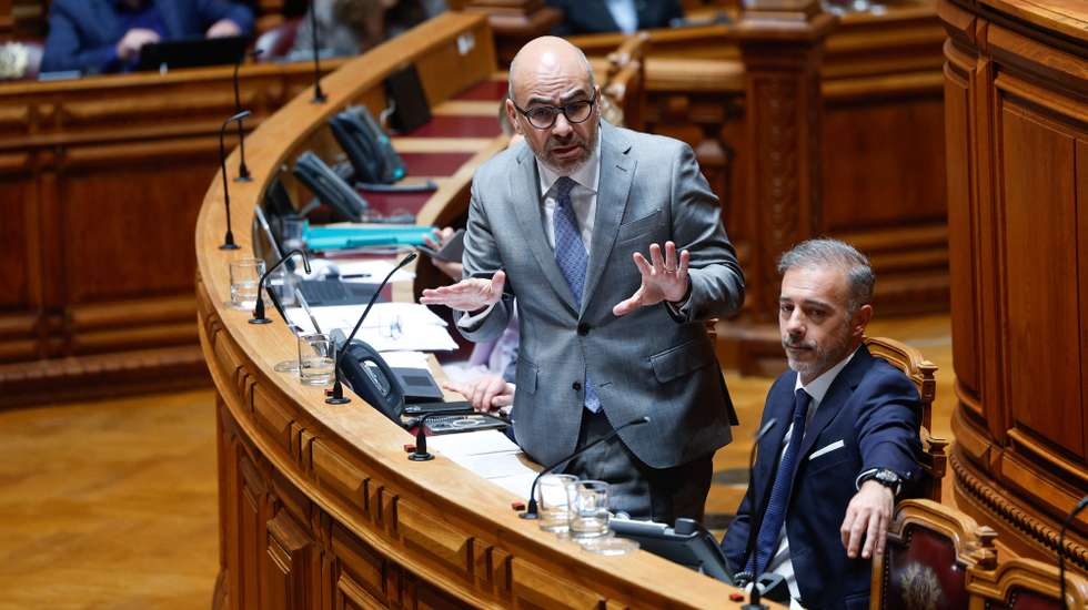 O ministro das Infraestruturas e Habitação, Miguel Pinto Luz, ladeado pelo ministro da Presidência e Assuntos Parlamentares, Pedro Duarte (D), intervém durante a sessão plenária num debate sobre política setorial, na Assembleia da República, em Lisboa, 17 de maio de 2024. ANTÓNIO PEDRO SANTOS/LUSA