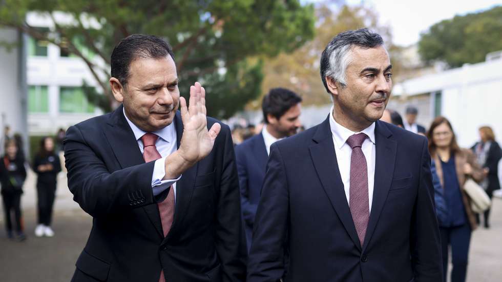 O primeiro-ministro, Luís Montenegro (E), acompanhado pelo ministro da Educação, Ciência e Inovação, Fernando Alexandre (D), acena aos alunos, durante a visita à escola secundária D. Dinis, em Lisboa, 22 de novembro de 2024. FILIPE AMORIM/LUSA