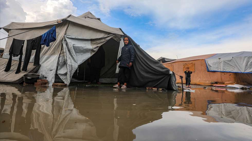epa12525396 A displaced Palestinian girl walks through a puddle outside her family's tent during a rainy day at a makeshift camp west of Gaza City, Gaza Strip, 14 November 2025. Around 1.9 million people in Gaza, nearly 90 percent of the population, have been displaced since the Israel-Hamas conflict began in October 2023, according to the UN.  EPA/MOHAMMED SABER
