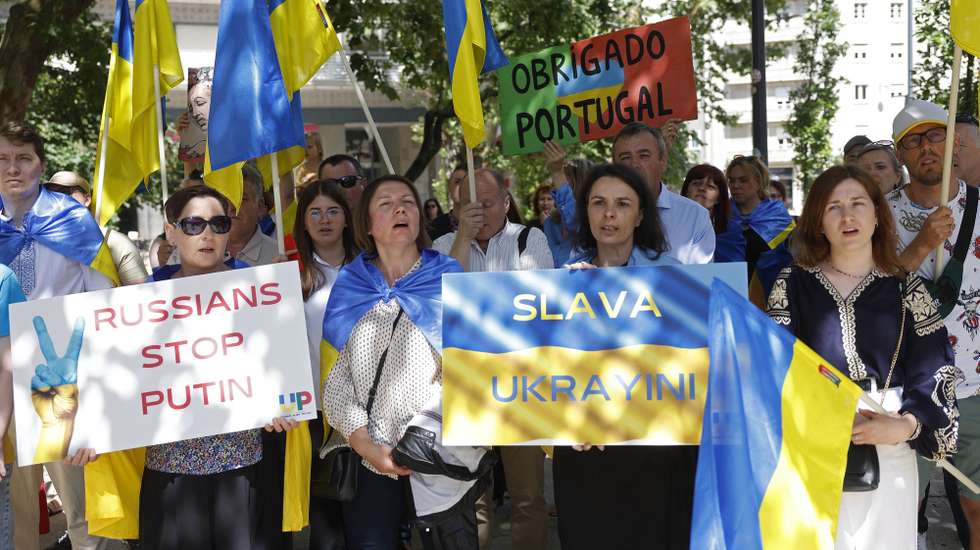 Manifestantes protestam durante a ação "StopEcocideUkraine", promovida pela Associação dos Ucranianos em Portugal, com o objetivo de "destacar os crimes de guerra da Rússia na Ucrânia, em particular, o ecocídio cometido pela Rússia e exigir justiça, responsabilização e respeito pelos direitos humanos", em frente à Embaixada de Moscovo, em Lisboa, 11 de junho de 2023. ANTÓNIO PEDRO SANTOS/LUSA