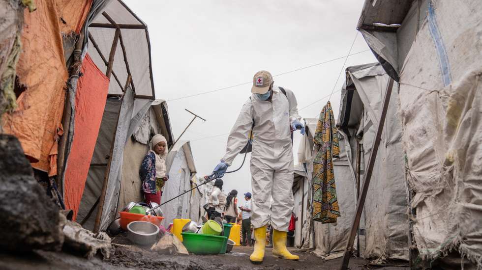 epa11559879 A Red Cross worker sprays chlorine as other Red Cross personnel raised awareness about mpox and hygiene among internally displaced people in the Don Bosco camps in Goma, Democratic Republic of Congo, 22 August 2024. The World Health Organization has declared the ongoing outbreaks of monkeypox (MPOX) in Congo and elsewhere in Africa a global emergency. Mpox causes fever, rash, and lesions all over the body, severe headaches, and fatigue.  EPA/MOISE KASEREKA