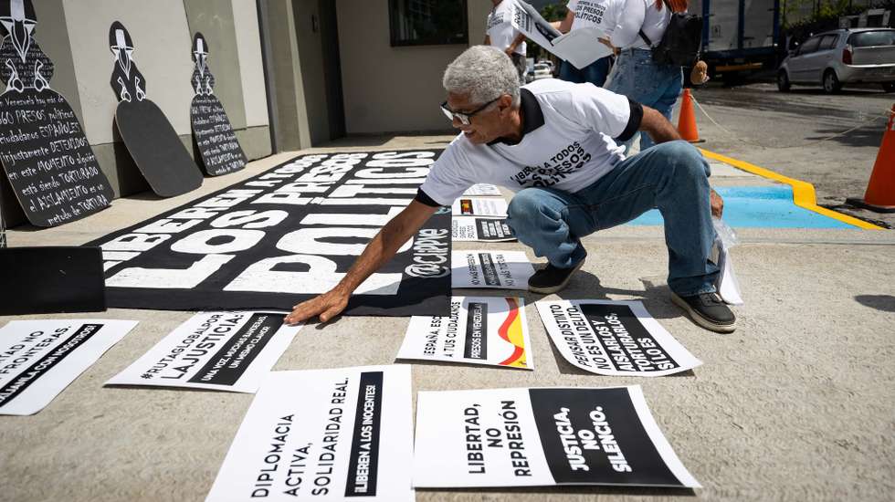 epa12381127 A man organizes posters during a rally for political prisoners in front of the Spanish embassy in Caracas, Venezuela 15 September 2025. The NGO Committee for the Freedom of Political Prisoners asked Spain to use its 'influence and leadership' to promote the release of political prisoners in Venezuela through 'diplomatic channels.'  EPA/RONALD PENA R