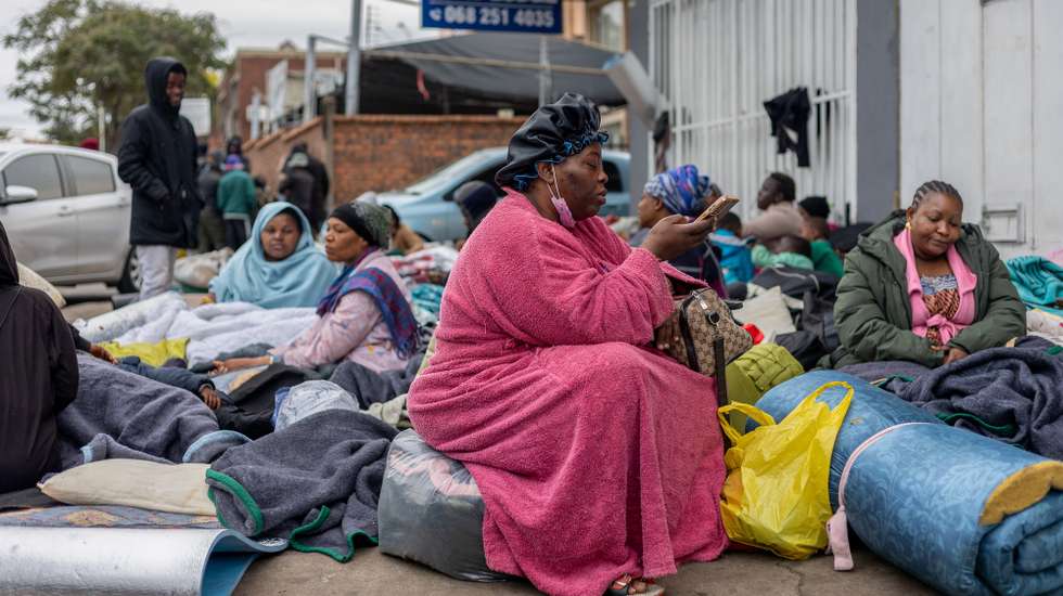 epa13075201 Migrant workers shelter outside a Home Affairs building during a nationwide anti-immigrant movement shutdown in Durban, South Africa, 30 June 2026. Marches are planned across South Africa as a large number of organizations under the umbrella of the 'March and March movement' take to the streets of major cities to protest against the high number of legal and illegal immigrants living in the country. Although the protesters issued an ultimatum demanding that foreign nationals leave South Africa by 30 June, the South African government has explicitly rejected the shutdown and declared June 30 a normal working day.  EPA/STRINGER