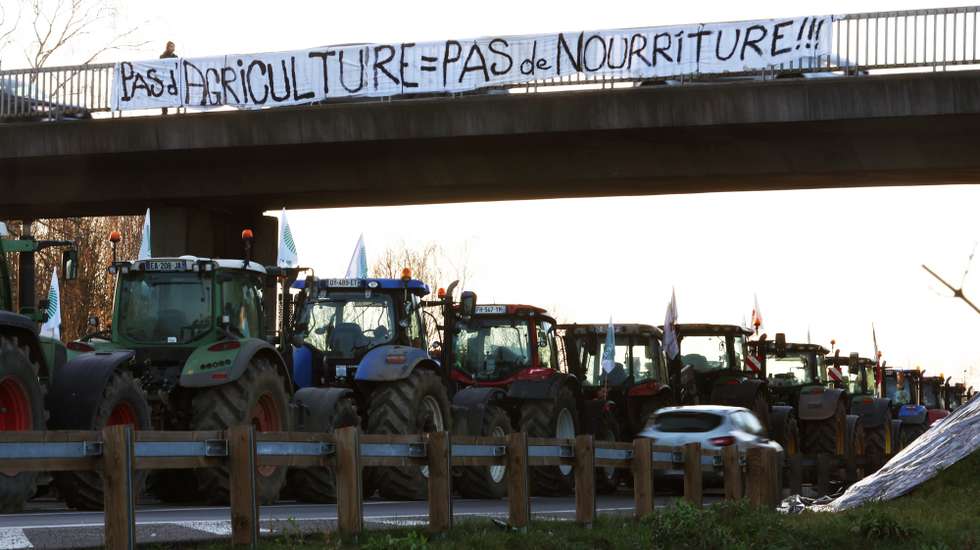 epa11106567 A banner reading 'No agriculture, no food' is displayed on a bridge as dozens of tractors block the A-15 motorway near Ableiges, north of Paris, France, 26 January 2024. French farmers continue their protests with road blockades and demonstrations in front of state buildings awaiting a response from the government to their request for 'immediate' aid of several hundred million euros. On 23 January, the EU Agriculture and Fisheries Council highlighted the importance of providing the conditions necessary to enable EU farmers to ensure food security sustainably and profitably, as well as ensuring a fair income for farmers.  EPA/Mohammed Badra