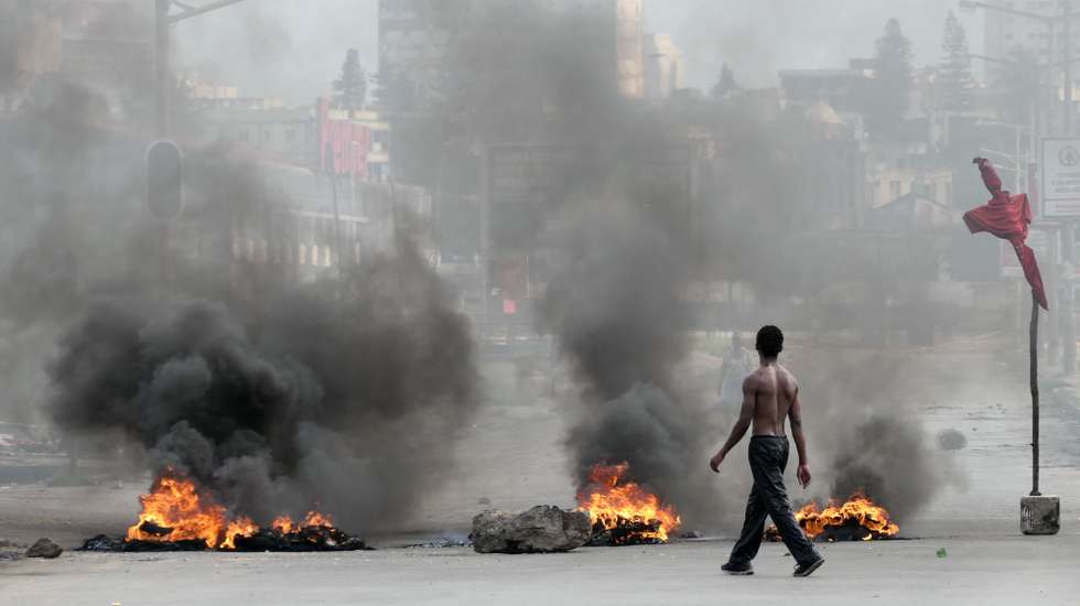 epaselect epa11791179 A man walks next to a burning barricade during a protest after the Constitutional Council proclaimed Daniel Chapo as the winner of the presidential election with 65.17% of the votes, in Maputo, Mozambique, 23 December 2024. Daniel Chapo was proclaimed on 23 December as the fifth President of Mozambique following the elections held in October 2024.  EPA/PAULO JULIAO