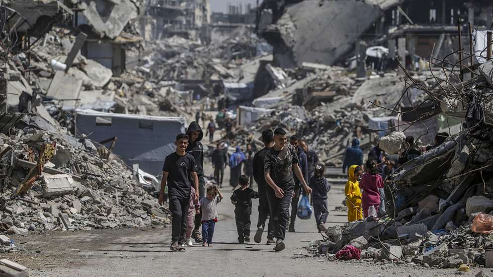 epa12007443 Internally displaced Palestinians walk past the rubble of destroyed buildings in the Jabalia refugee camp, northern Gaza Strip, 03 April 2025, after the Israeli army issued evacuation orders for areas in the northern and eastern Gaza Strip. Israeli forces resumed airstrikes on Gaza on 18 March, ending a ceasefire that had been in place since 19 January.  EPA/MOHAMMED SABER