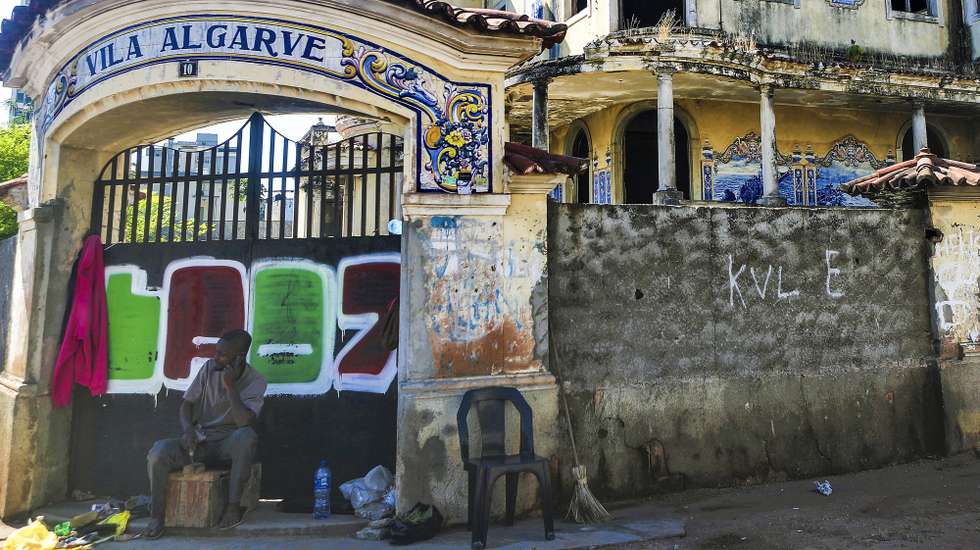 Celestino, sapateiro, encontrou na sombra da entrada da Vila Algarve, Maputo, o local para trabalhar, alheio às histórias de terror das ruínas da antiga prisão da PIDE a que 50 anos de independência não conseguiram dar nova vida, Maputo, Moçambique, 26 de maio de 2025. (ACOMPANHA TEXTO DA LUSA DE 23-06-2025) LUÍSA NHANTUMBO/LUSA