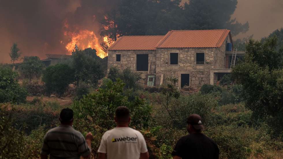 epa12312899 Local residents look on during a forest fire in Lourical do Campo, Castelo Branco, Portugal, 20 August 2025. According to preliminary official data, as of August 19, 2025, over 201,000 hectares had burned in Portugal, surpassing the total burned in all of 2024.  EPA/PAULO NOVAIS