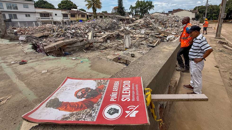 epa13185639 People view the rubble of the Torres del Limonar building, which was damaged by an earthquake, in Cali, Colombia, 22 August 2026. Heavy machinery works to clear remaining rubble after search and rescue operations ended at sites where buildings collapsed following a 7.4-magnitude earthquake.  EPA/Mario Baos
