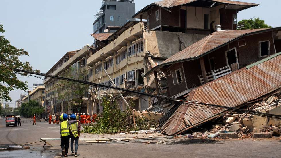 epa11998661 Rescuers walk next to the site of a collapsed building following an earthquake in Mandalay, Myanmar, 30 March 2025. More than 1,600 people have been killed and thousands injured after a 7.7-magnitude earthquake struck the country on 28 March, according to the Myanmar government.  EPA/STRINGER