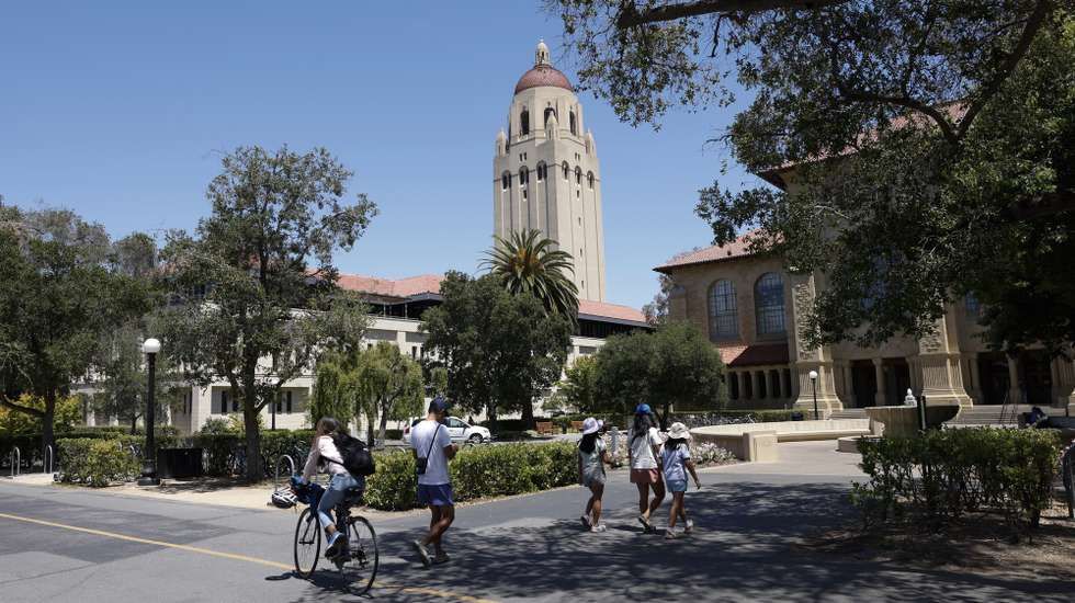 epa12146395 People walk and ride along the campus of Stanford University, in Stanford, California, USA, 30 May 2025. Stanford University faculty, alumni and students held a small rally expressing concerns and protesting the Trump administration's investigations of Stanford and several campuses with the University of California system of their admissions policies, defunding of universities research projects, rallied support for protecting their international student's rights.  EPA/JOHN G. MABANGLO
