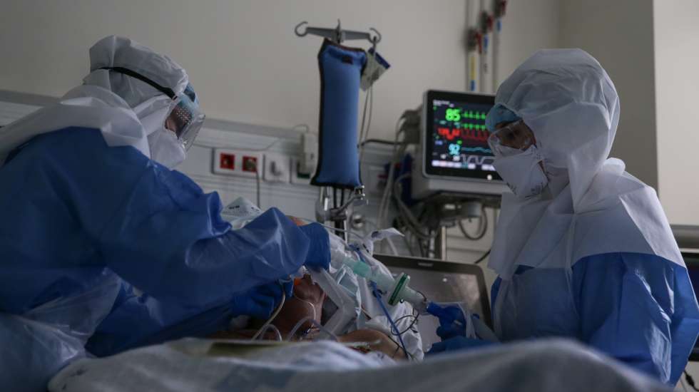 Enfermeiras cuidam de um paciente hospitalizado na Unidade de Cuidados Intensivos Covid 19 do Hospital Santa Maria em Lisboa, 27 de outubro de 2020. A urgência dedicada aos casos suspeitos de covid-19 do Hospital Santa Maria, em Lisboa, reflete a evolução da pandemia em Portugal com doentes a avolumarem-se à porta para realizar o teste e no interior a capacidade quase esgotada. O medo de perder o emprego leva muitos doentes com covid-19 a esconderem que estão infetados e a continuar a trabalhar, disseminando a doença que, nesta fase, começa a ser um caso também social e que leva a muitos internamentos no Santa Maria. (ACOMPANHA TEXTO DA LUSA DE 30 DE OUTUBRO DE 2020) TIAGO PETINGA/LUSA