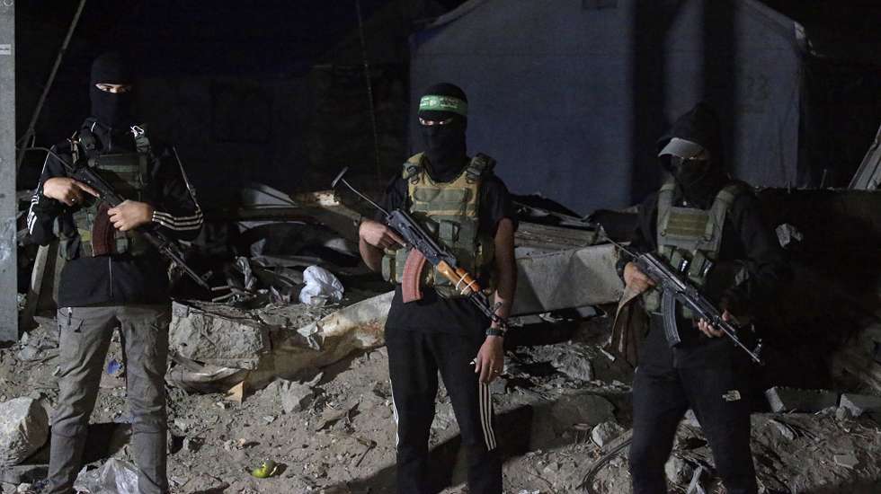 epaselect epa12456504 Palestinian fighters from Hamas's Izz ad-Din al-Qassam Brigades guards as vehicles of the International Committee of the Red Cross (ICRC) arrive to transport remains of Israeli hostages handed over by Hamas in Gaza City, 15 October 2025. The first phase of the Gaza peace agreement, reached between Israel and Hamas, includes the release of Israeli hostages and Palestinian prisoners, a partial withdrawal of Israeli forces, and the delivery of humanitarian aid to Gaza.  EPA/MOHAMMED SABER