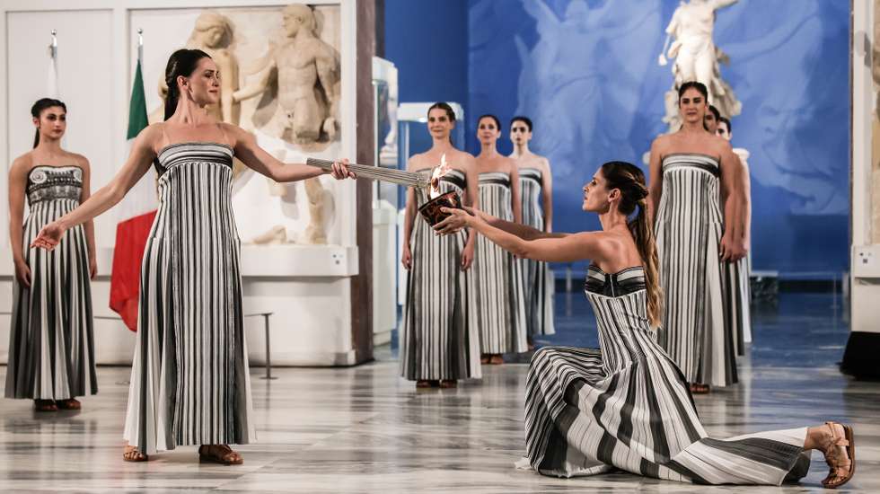epa12549789 A handout photo made available by Presidency of the Hellenic Republic shows Greek actress Mary Mina (L), playing the role of High Priestess, lighting the flame during the Olympic flame lighting ceremony for the Milano Cortina 2026 Winter Olympics at the Archaeological Museum of Olympia, in southern Greece, 26 November 2025. The Milano Cortina 2026 Winter Olympics will be held from 06 February to 22 February 2026.  EPA/THODORIS MANOLOPOULOS HANDOUT HANDOUT EDITORIAL USE ONLY/NO SALESHANDOUT EDITORIAL USE ONLY/NO SALES
