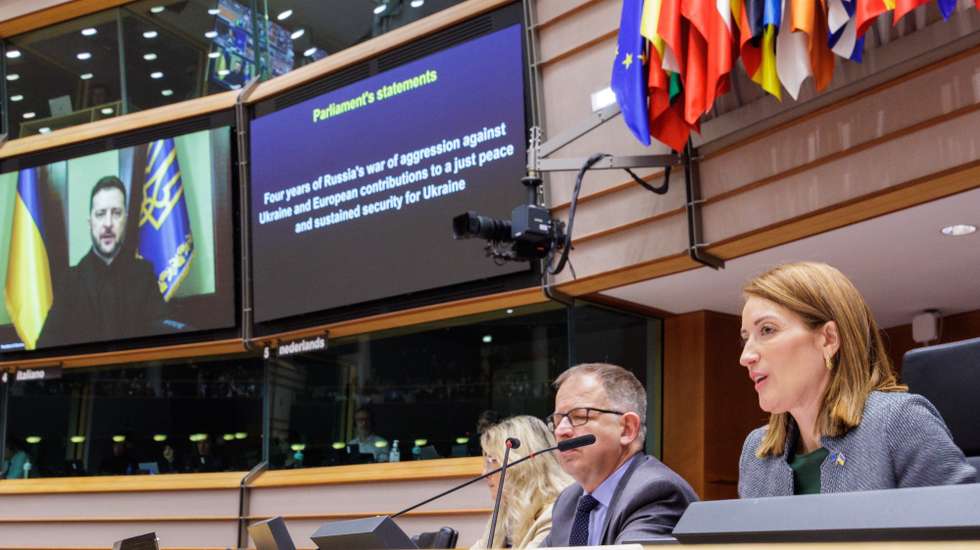 epa12772951 President of the European Parliament Roberta Metsola (R) looks on as Ukraine's President Volodymyr Zelenskyy (on screen) addresses an extraordinary plenary session of the European Parliament on the fourth anniversary of Russia's invasion of Ukraine in Brussels, Belgium, 24 February 2026.  EPA/OLIVIER MATTHYS
