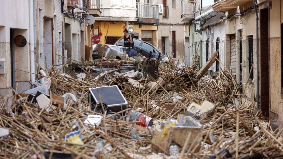 epa11692837 A resident walks over debris in the flood-hit municipality of Paiporta, in the province of Valencia, Spain, 30 October 2024. The intense rainfall impacting the eastern part of the country resulted in at least 70 lives being lost in the province of Valencia and neighboring provinces due to the flooding. The mayor of Paiporta, located about ten kilometers southwest of Valencia, confirmed that at least 34 people died in the municipality due to the flooding. The State Meteorological Agency (AEMET) issued orange and red alerts for rainfall in multiple regions of east and southern Spain due to a DANA (isolated depression at high levels) phenomenon.  EPA/MANUEL BRUQUE